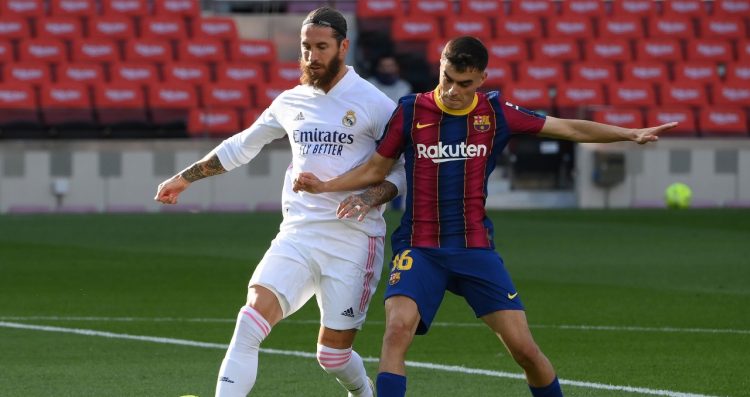 El centrocampista español del Barcelona Pedri (R) desafía al defensor español del Real Madrid Sergio Ramos durante el partido de fútbol de la Liga española entre el Barcelona y el Real Madrid en el Camp Nou. LLUIS GENE / AFP