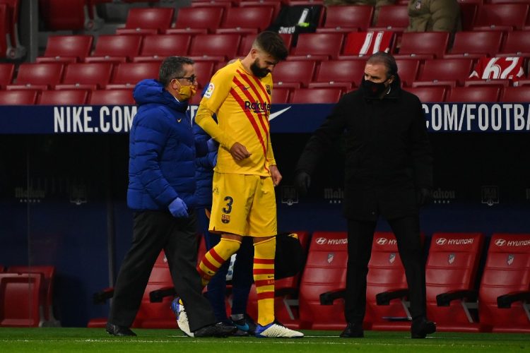 El defensor español de Barcelona, ​​Gerard Piqué (L), reacciona mientras camina fuera del campo después de lesionarse durante el partido de fútbol de la Liga española entre el Club Atlético de Madrid y el FC Barcelona. NIÑOS GABRIEL / AFP