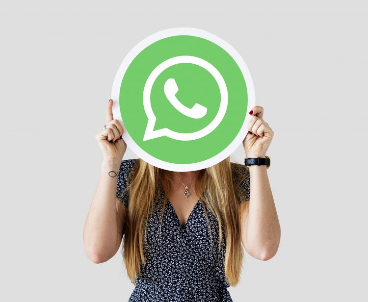 Woman showing a WhatsApp Messenger icon