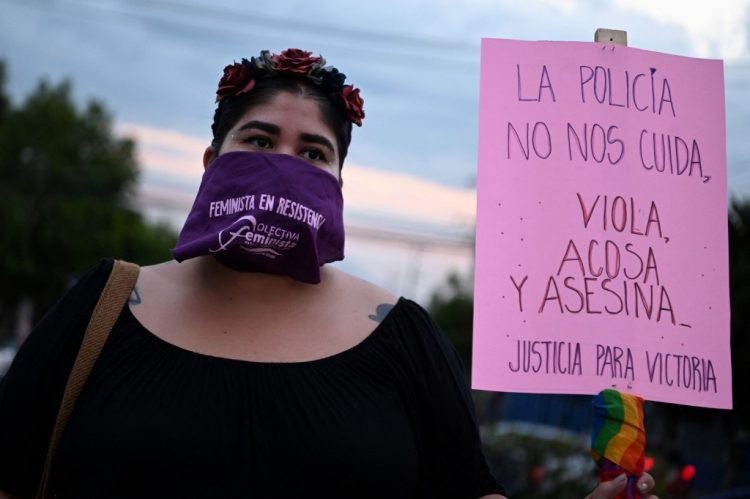 Una mujer sostiene un cartel durante una manifestación denominada «Justicia para Victoria» por la muerte de la salvadoreña Victoria Esperanza Salazar, quien fue sometida por la policía en Tulum, un balneario del Caribe mexicano, en San Salvador, el 29 de marzo de 2021.