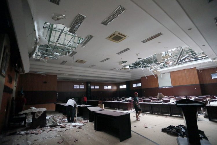 Los trabajadores limpian los escombros del vestíbulo de un edificio del parlamento local en Blitar, Java Oriental, el 10 de abril de 2021, después de que un terremoto de magnitud 6,0 sacudiera la costa de la isla de Java en Indonesia. FOTO / AFP