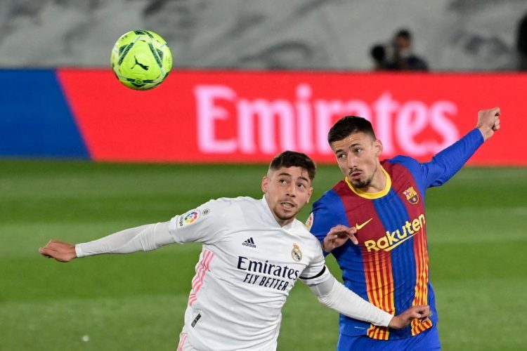 El centrocampista uruguayo del Real Madrid Federico Valverde (L) y el defensa francés del Barcelona Clement Lenglet saltan por el balón durante el Clásico. (Photo by JAVIER SORIANO / AFP)