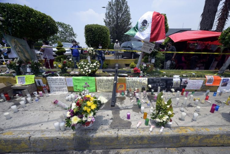 Un altar con velas, flores y mensajes se ve cerca del tramo de una vía elevada que colapsó provocando la caída de un tren el 3 de mayo, una semana después del accidente del 10 de mayo de 2021, en la Ciudad de México. FOTO / AFP
