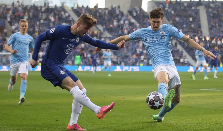 El defensor inglés del Manchester City John Stones (R) lucha por el balón con el delantero alemán del Chelsea Timo Werner (L) durante el partido de fútbol de la final de la Liga de Campeones de la UEFA entre el Manchester City y el Chelsea en el estadio Dragao de Oporto. (Photo by CARL RECINE / POOL / AFP)