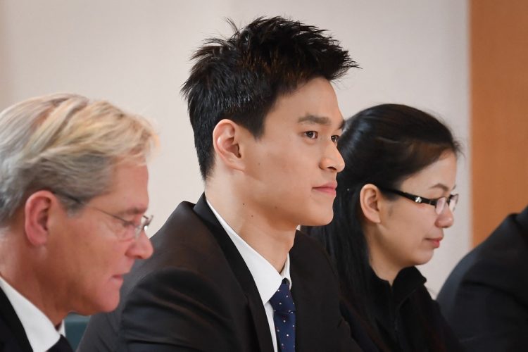 En esta foto de archivo tomada el 15 de noviembre de 2019, la estrella de natación china Sun Yang (C), acusada de romper un frasco de sangre con un martillo, mira entre sus abogados Ian Meaking (L) y Luo Xiaoshuang antes de su audiencia pública. FOTO / AFP
