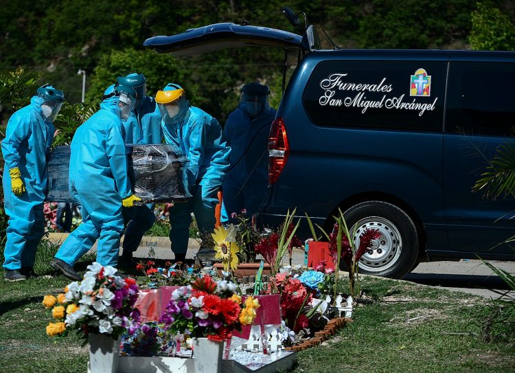 Defunciones. Las familias hondureñas han tenido que presenciar de lejos la sepultura de 6,877 personas que fueron contagiadas a más del año de la aparició del virus en el territorio. Foto AFP.