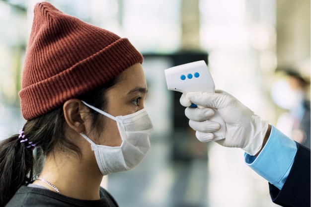 mujer mascara medica obteniendo su temperatura medida termometro electronico 53876 94738