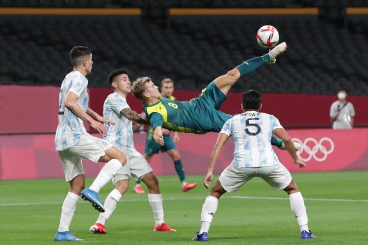 El mediocampista australiano Riley McGree (C) intenta un tiro por encima de la cabeza durante el partido de fútbol de primera ronda del grupo C masculino de los Juegos Olímpicos de Tokio 2020 entre Argentina y Australia en el Sapporo Dome en Sapporo el 22 de julio de 2021. FOTO / AFP