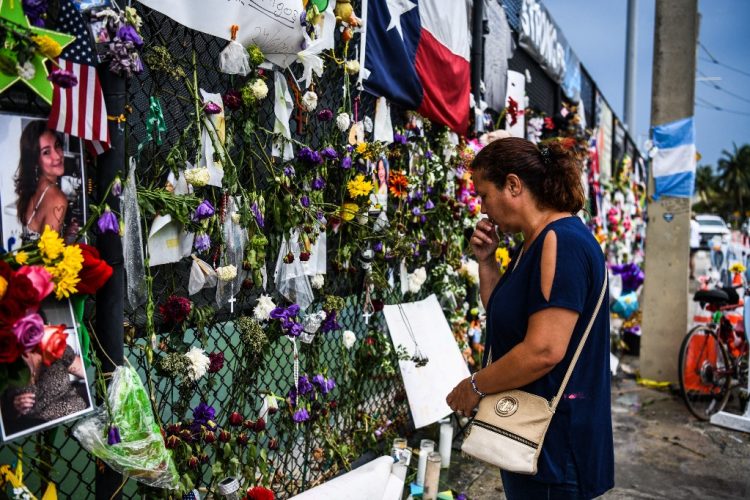 Una mujer reza mientras visita un memorial improvisado donde se encontraba el edificio Champlain Towers South parcialmente derrumbado en Surfside, Florida, el 24 de julio de 2021. FOTO / AFP