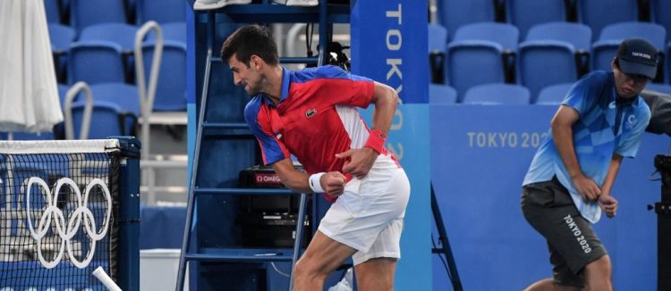 Novak Djokovic rompe su raqueta durante su partido de tenis individual masculino de los Juegos Olímpicos de Tokio 2020 por la medalla de bronce contra el español Pablo Carreño Busta en el Ariake Tennis Park de Tokio. (Photo by Tiziana FABI / AFP)