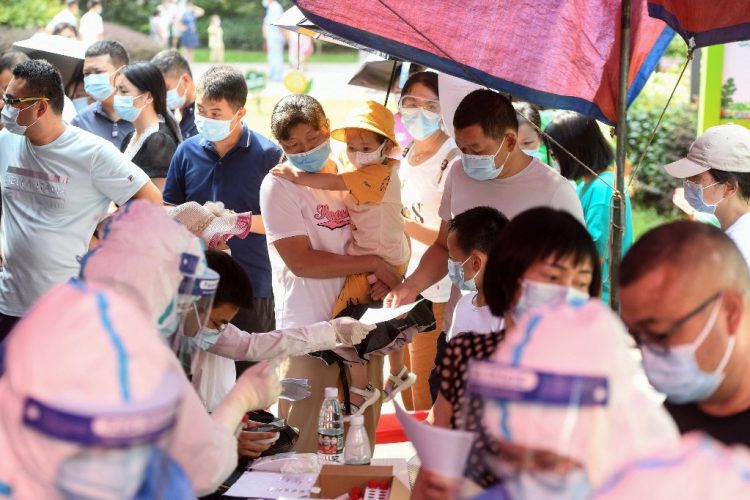 Los residentes hacen cola para realizar pruebas de ácido nucleico para el coronavirus en Wuhan, en la provincia central de Hubei, en China, el 3 de agosto de 2021, mientras la ciudad analiza a toda su población para detectar Covid-19. FOTO / AFP