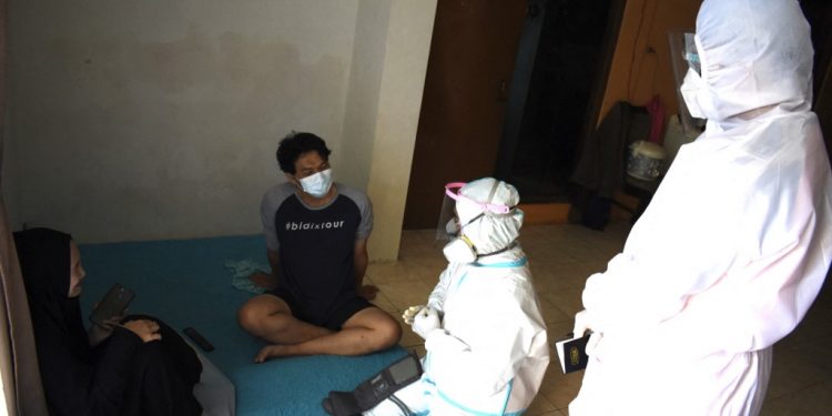 Health workers check on residents that are self isolating at home during the Covid-19 coronavirus pandermic at home in Bandung on August 4, 2021. (Photo by Timur Matahari / AFP)