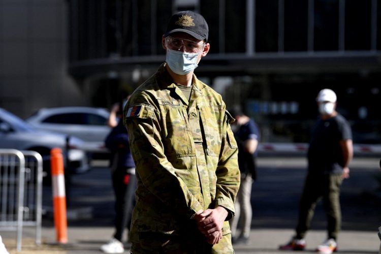 Un miembro de las fuerzas armadas australianas se encuentra fuera de un centro de vacunación masiva contra el coronavirus Covid-19 en Sydney el 18 de agosto de 2021. FOTO / AFP