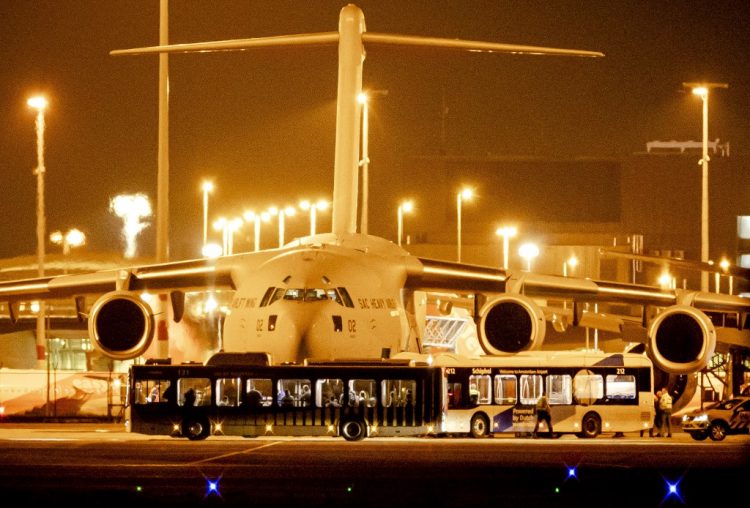 Pasajeros de Afganistán desembarcan de un avión C-17 utilizado por varios países de la OTAN, en una plataforma del aeropuerto de Schiphol cerca de Ámsterdam, el 18 de agosto de 2021. FOTO / AFP