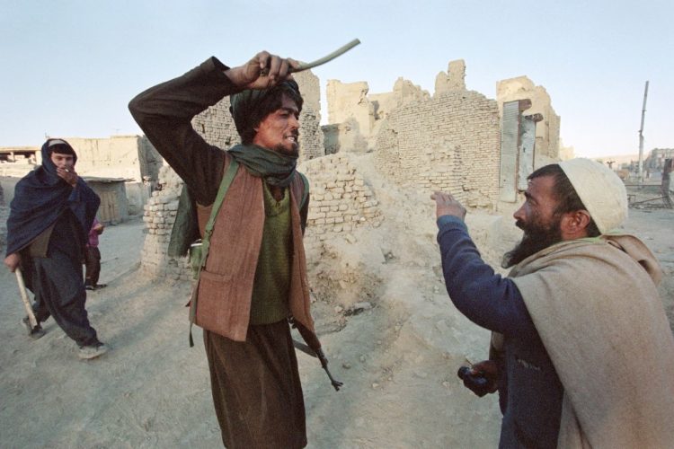 Un miliciano talibán golpea a un civil con un palo mientras lo arresta después de que el hombre fuera encontrado en posesión de medio kilogramo de opio el 6 de noviembre de 1996 en Kabul. FOTO / AFP