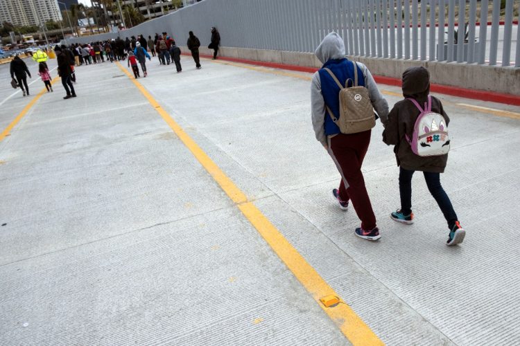Migrantes y solicitantes de asilo se mueven después de una manifestación el 23 de marzo en el puerto de cruce de San Ysidro pidiendo a las autoridades estadounidenses que les permitan iniciar su proceso migratorio en Tijuana. Foto AFP.