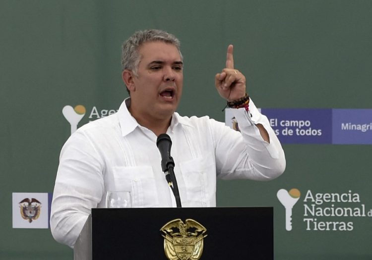 En esta foto de archivo tomada el 30 de agosto de 2019, el presidente colombiano Iván Duque hace gestos mientras habla durante un evento para entregar títulos de propiedad de tierras a víctimas del conflicto en Ovejas, norte de Colombia. FOTO / AFP