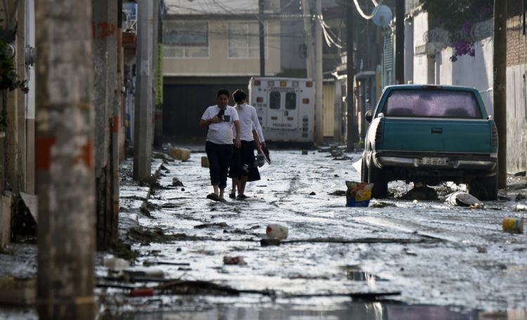La gente camina por una calle inundada después de que las fuertes lluvias cayeran sobre Tula de Allende, estado de Hidalgo, México, el 9 de septiembre de 2021. FOTO / AFP