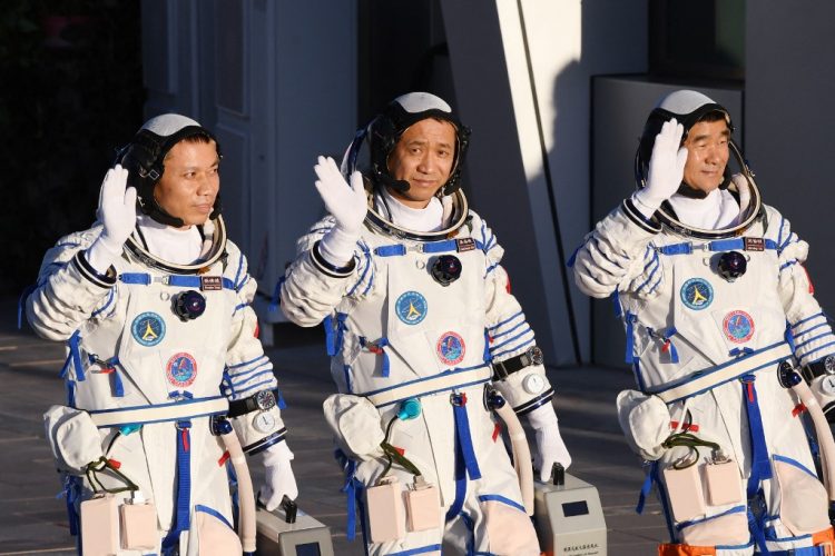 Esta foto de archivo tomada el 17 de junio de 2021 muestra a los astronautas Nie Haisheng (C), Liu Boming (R) y Tang Hongbo saludando durante una ceremonia de salida antes de abordar la nave espacial Shenzhou-12 en un cohete portador Long March-2F en el Centro de lanzamiento de satélites de Jiuquan en el desierto de Gobi en el noroeste de China. FOTO / AFP