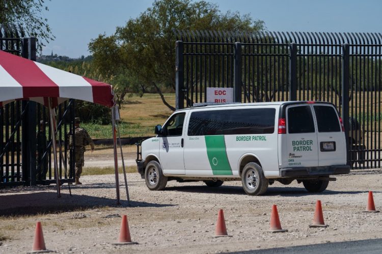A US Border Patrol van enters a gate to the area under the Del Rio-CIudad Acuna International Bridge where about 15,000 mostly Haitian migrants were waiting to enter the United States, in Del Rio, Texas on September, 25, 2021. (Photo by PAUL RATJE / AFP)