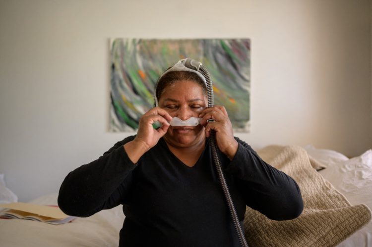 La ex trabajadora de limpieza de la Zona Cero del 11 de septiembre, Rubiela Arias, demuestra el uso de un dispositivo que usa, luego del diagnóstico de dificultades respiratorias asociadas con su trabajo en los ataques al World Trade Center. FOTO AFP