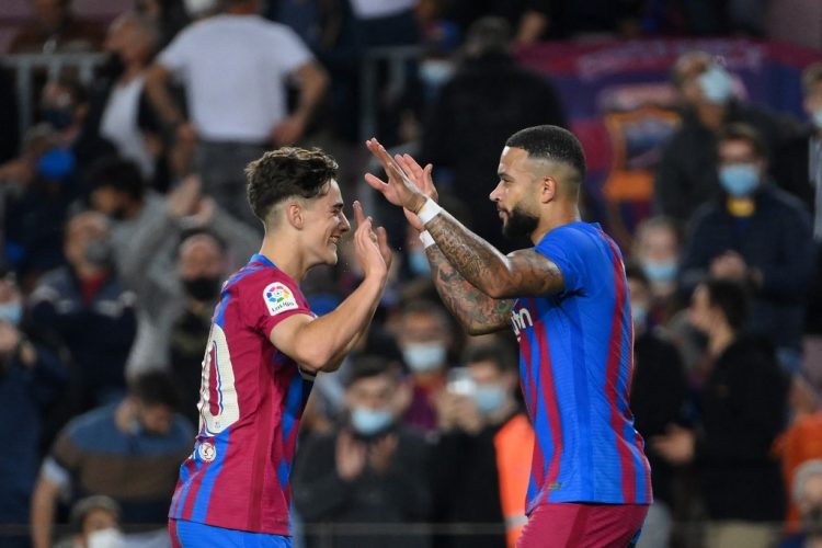 El delantero holandés del Barcelona Memphis Depay (R) celebra con el centrocampista español del Barcelona Gavi después de anotar el segundo gol de su equipo durante el partido de fútbol de la liga española entre el FC Barcelona y el Valencia CF en el estadio Camp Nou. (Photo by LLUIS GENE / AFP)