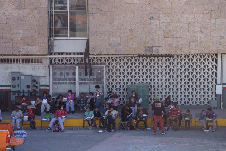 Un grupo de migrantes deportados esperan trámites en el INM.  Foto AFP.