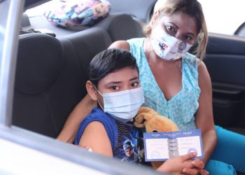 Adultos, niños y familias reciben la vacuna en el autoservicio de vacunación este jueves