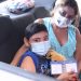Adultos, niños y familias reciben la vacuna en el autoservicio de vacunación este jueves
