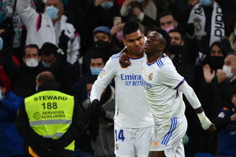 El delantero brasileño del Real Madrid Vinicius Junior (R) celebra con su compañero el centrocampista brasileño del Real Madrid Casemiro tras marcar un gol durante el partido de fútbol de la liga española entre el Real Madrid CF y el Sevilla FC. (Photo by GABRIEL BOUYS / AFP)