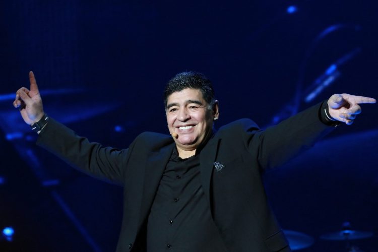 El exfutbolista argentino Diego Armando Maradona hace gestos en el escenario mientras saluda a la audiencia durante un espectáculo en la Plaza Plebiscito, en Nápoles, el 5 de julio de 2017.. (Photo by CARLO HERMANN / AFP)