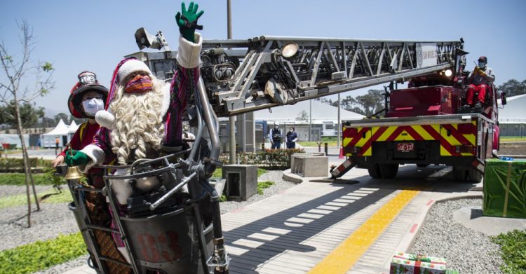 En escalera de bomberos Papá Noel entrega regalos a niños con covid-19 en Perú. FOTO/ AFP.