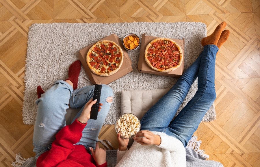 close up women with popcorn and pizza