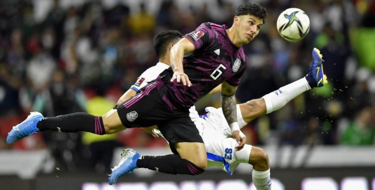 El futbolista salvadoreño Kevin Reyes (der.) compite por el balón con el mexicano Jorge Sánchez (izq.) durante su partido clasificatorio para la Copa Mundial de la FIFA Concacaf en el estadio Azteca de la Ciudad de México. (Photo by ALFREDO ESTRELLA / AFP)