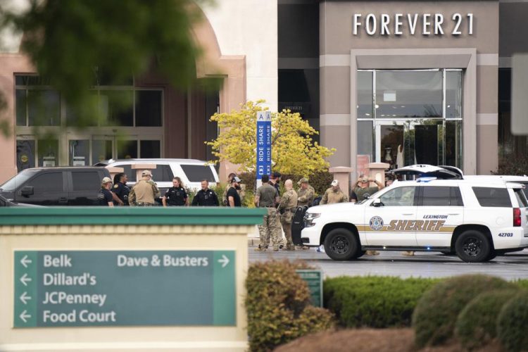 Miembros de la policía se reúnen frente al centro comercial Columbiana Center en Columbia, Carolina del Sur, luego de un tiroteo, el 16 de abril de 2022.