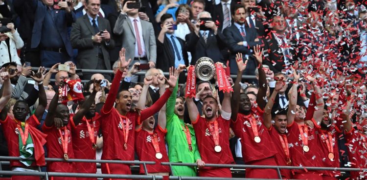 El mediocampista inglés del Liverpool, Jordan Henderson (centro), sostiene el trofeo mientras celebra con sus compañeros de equipo después de ganar la final de la Copa FA inglesa entre Chelsea y Liverpool, en el estadio de Wembley. (Photo by Ben Stansall / AFP) / NOT FOR MARKETING OR ADVERTISING USE / RESTRICTED TO EDITORIAL USE
