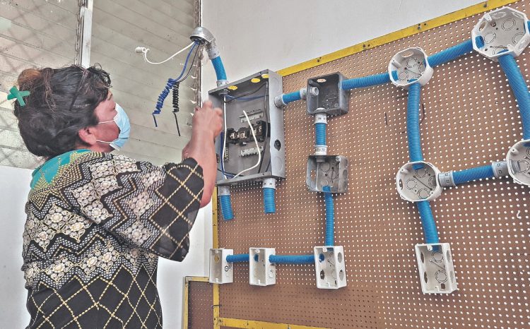Práctica. La mujer pone mucho empeño en el curso de electricidad, que imparte el Insaforp en Usulután.