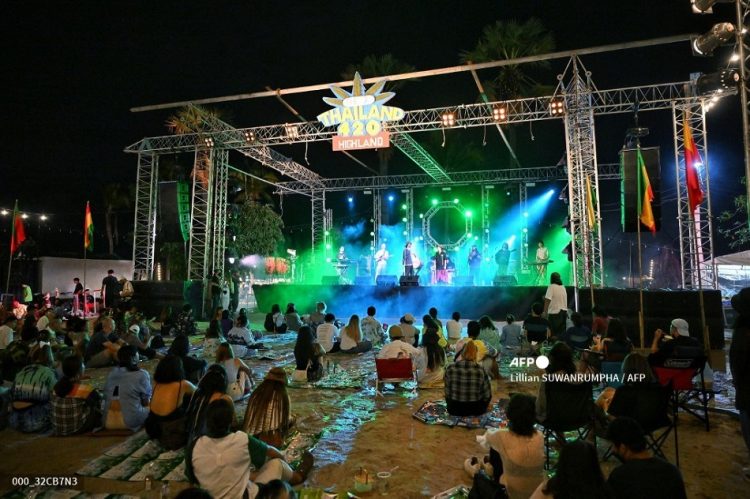 People listen to bands as they gather to celebrate the legalization of cannabis at the Thailand: 420 Legalaew! weekend festival hosted by Highland in Nakhon Pathom province on June 11, 2022. (Photo by Lillian SUWANRUMPHA / AFP)