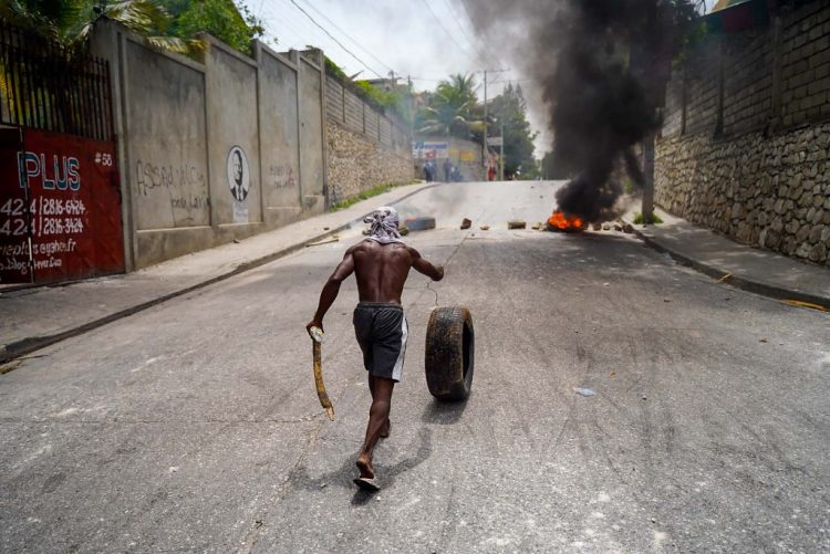 Haitians protesting high prices and shortages burn tires on a street of Port-au-Prince on July 13, 2022. - Soaring prices, food and fuel shortages and rampant gang violence are accelerating a brutal downward spiral in the security situation in the Haitian capital Port au Prince,  and threatening the humanitarian aid the increasingly desperate population relies on. (Photo by Richard Pierrin / AFP)