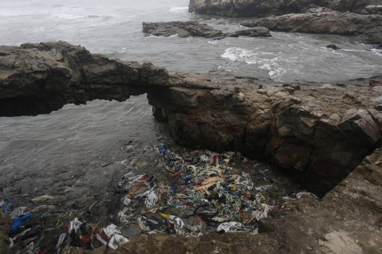 Garbage is seen at the shore of Cavero Beach, which was affected by an oil spill that occurred on January 15 and involved Spanish energy giant Repsol, in Pachacutec, an area on the northern outskirts of Lima, on July 09, 2022. - Described as an "ecological disaster" by the Peruvian government, the spill occurred while the Italian-flagged tanker "Mare Doricum" was unloading crude oil at the La Pampilla refinery in Ventanilla, owned by the Spanish oil company Repsol. The company attributed the fact to the agitation of the sea by a volcanic eruption in Tonga, on the other side of the Pacific. (Photo by Gian Masko / AFP)