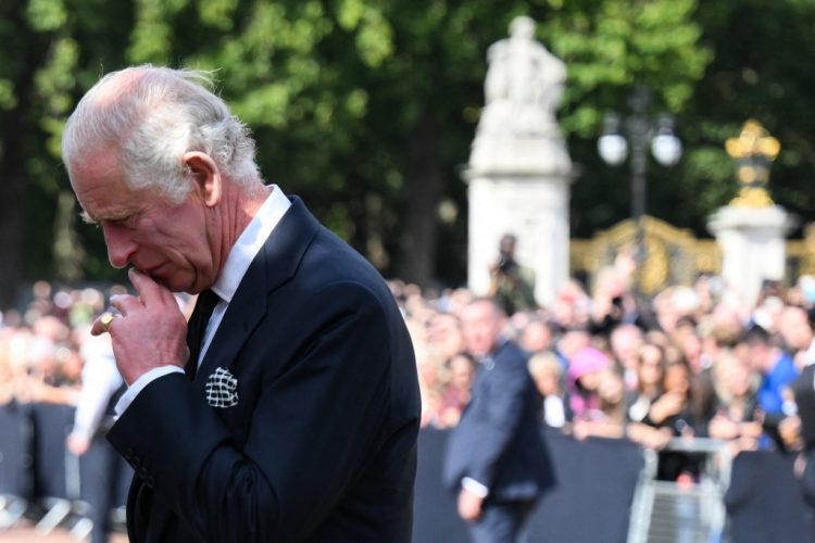 Britain's King Charles III looks at floral tributes left outside of Buckingham Palace in London, on September 9, 2022, a day after Queen Elizabeth II died at the age of 96. - Queen Elizabeth II, the longest-serving monarch in British history and an icon instantly recognisable to billions of people around the world, died at her Scottish Highland retreat on September 8. (Photo by Daniel LEAL / AFP)