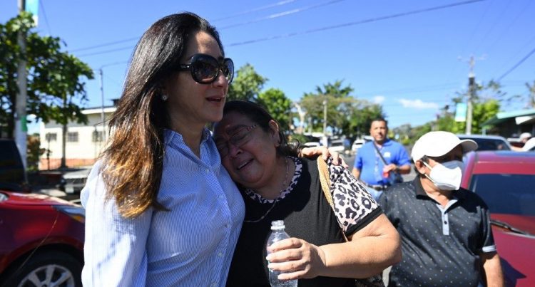 La ministra de vivienda, Michelle Sol, abraza a Ana Vilma Cuellar, quien recuperó su casa en La Campanera. Foto: AFP