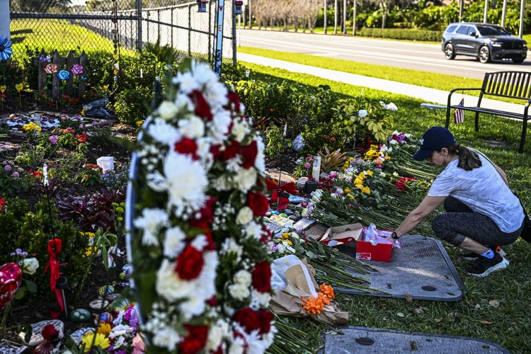 Una mujer rinde homenaje en el monumento a las víctimas del tiroteo en la escuela secundaria Marjory Stoneman Douglas en Parkland, Florida, que mató a 17 personas, en el quinto aniversario de la masacre el 14 de febrero de 2023. Foto AFP.