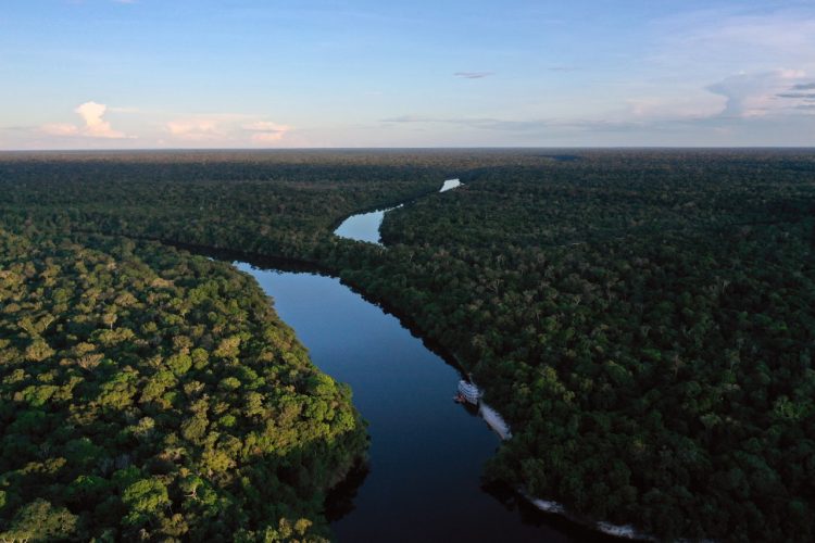 A drone view shows the Almirante Moreira VII vessel docked at the Manicore river, deep inside the Amazonia rainforest, Amazonas state, Brazil, on June 7, 2022. - The boat is the floating base of a research expedition organized by Greenpeace in partnership with the National Institute for Amazonian Research (INPA). (Photo by MAURO PIMENTEL / AFP)