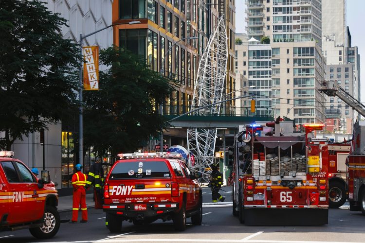 Firefighters inspect a construction crane tha caught fire and collapsed in New York, on July 26, 2023. - The New York City Fire Department reported two firefighters and at least four civilians suffered minor injuries in the accident. (Photo by Kena Betancur / AFP)