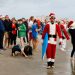 Papás Noel surfistas toman una playa de Florida por diversión y una buena causa