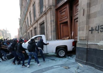 Manifestantes de Ayotzinapa derriban con vehículo la puerta del palacio presidencial en México