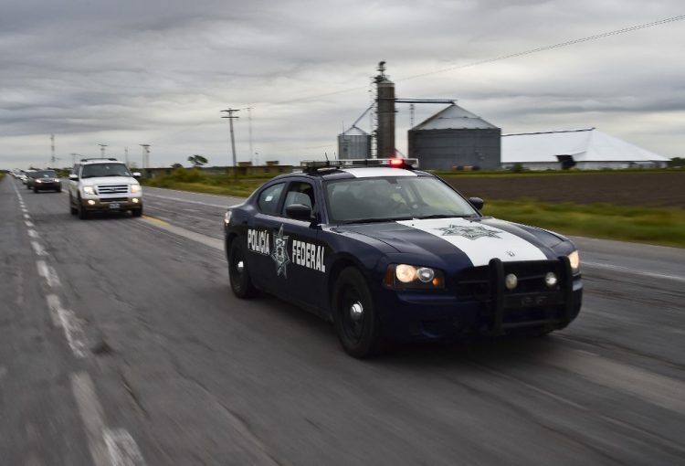 TO GO WITH AFP STORY BY SOFIA MISELEM
A Federal Police patrol car escorts vehicles with civilians along the gang-infested Matamoros-Ciudad Victoria highway, Tamaulipas State, Mexico, in the border with the United States, on December 16, 2015. AFP PHOTO/RONALDO SCHEMIDT (Photo by RONALDO SCHEMIDT / AFP)