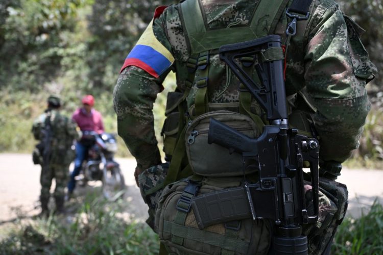 (FILES) Members of the Carlos Patino front of the dissident FARC guerrilla patrol in Micay Canyon, a mountainous area and EMC stronghold in Cauca Department, southwestern Colombia, on March 24, 2024. The Colombian Army killed in combat 15 members of a dissident faction of the now-defunct FARC guerrilla group that walked out of peace negotiations last week, as reported on April 25, 2024. (Photo by Raul ARBOLEDA / AFP)