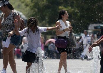Children cool themself down in a water fountain during a heat wave hitting the country in Guadalajara, Jalisco state, Mexico, on May 23, 2024. (Photo by ULISES RUIZ / AFP)